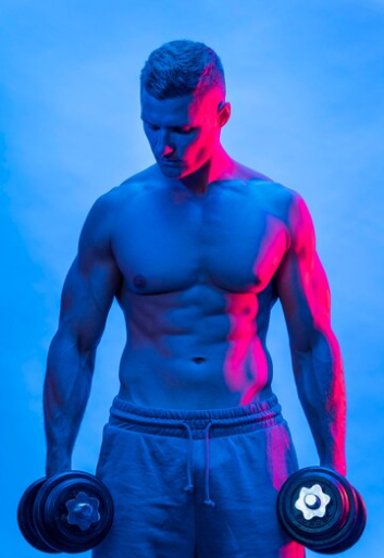 Спортивный мужчина с гантелями на синем фоне